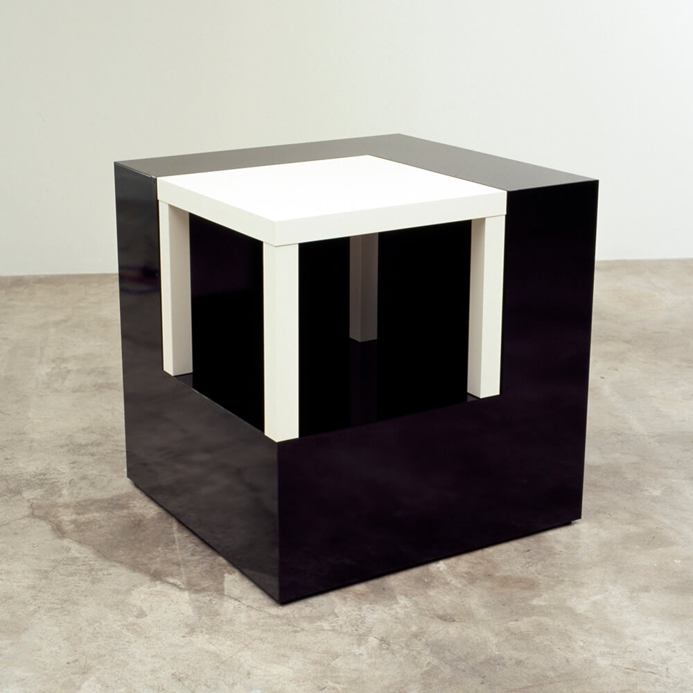 Ein glattes, quadratisches Objekt, dessen eine Ecke aus einer Art weißem Tisch besteht.