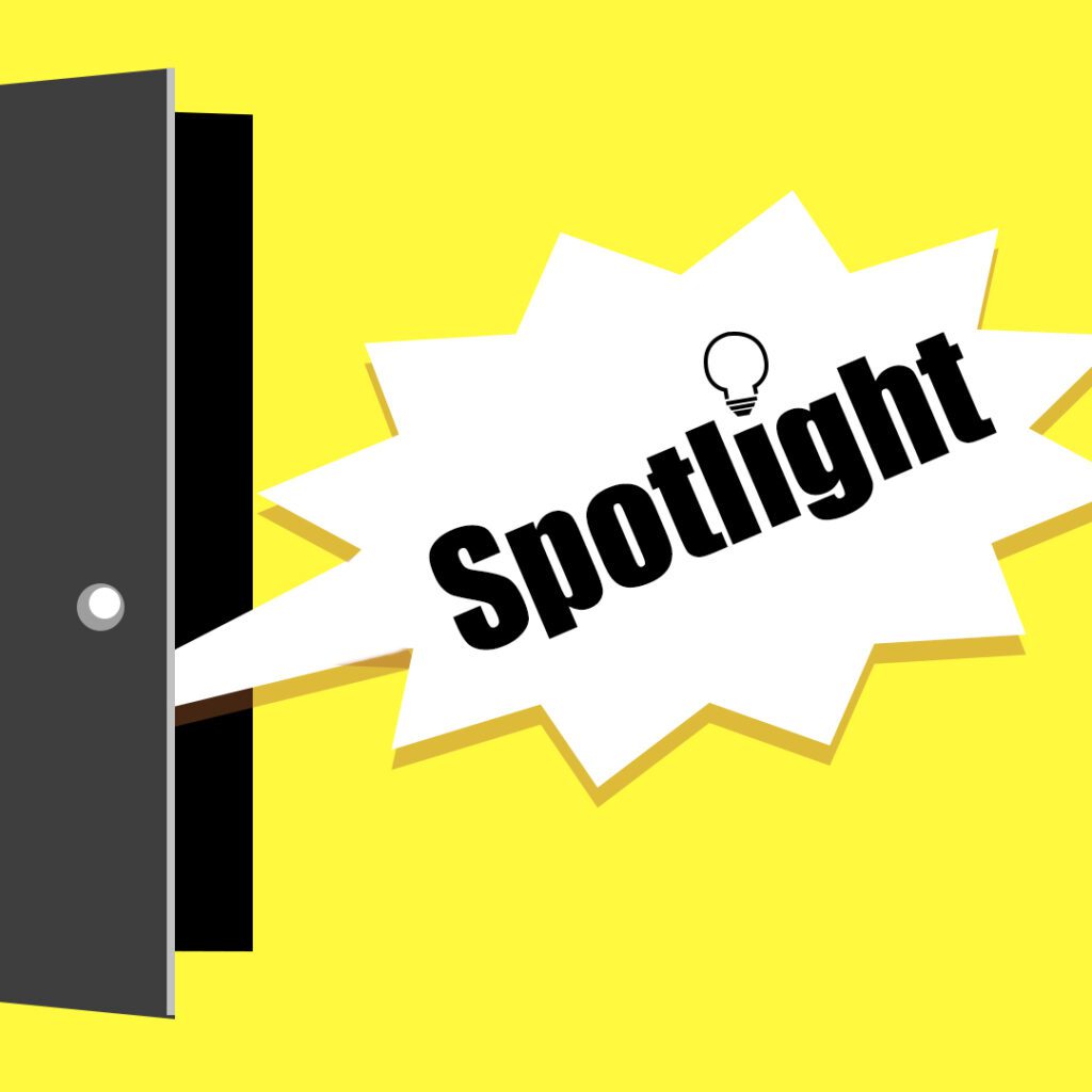 Aus einer leicht geöffneten Tür erscheint eine eckige Sprechblase mit dem Wort "Spotlight" in dicken schwarzen Buchstaben. Anstelle des i-Punktes steht eine Glühbirne. Der Hintergrund ist zitronengelb.