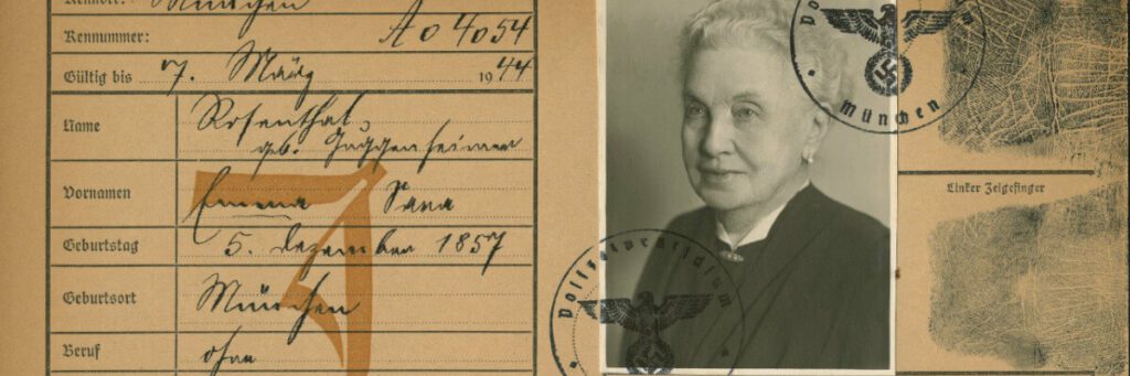 Eine Papierkarte mit einigen biografischen Daten und Stempeln aus der NS-Zeit. Auf der Karte klebt außerdem ein Schwarzweißfoto einer alten Frau mit grauen Haaren.