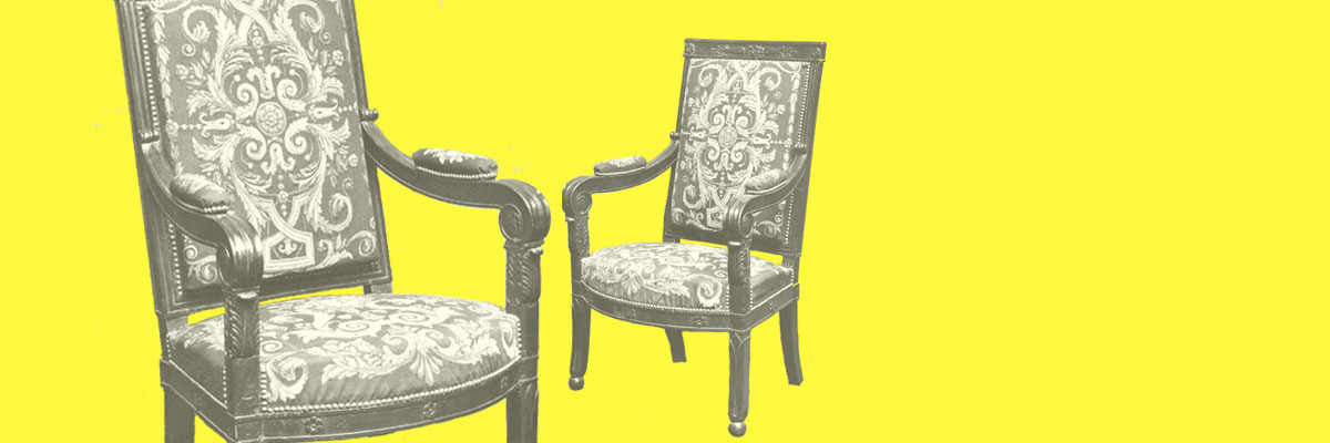 Zwei reich verzierte Holzstühle vor einem zitronengelben Hintergrund. Die Polster der Stühle sind mit aufwendigen Ornamenten bestickt.
