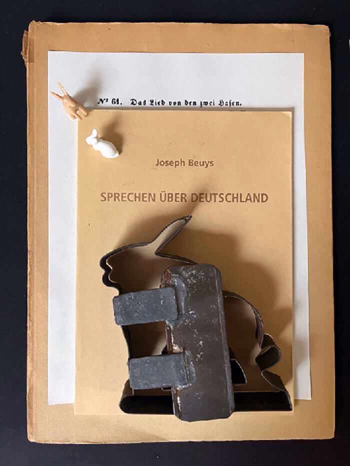 Übereinanderliegend: Heftchen und ausgedruckte Blätter. Das oberste trägt den Titel "Sprechen über Deutschland". Oben drauf eine Bachform (Hase) und zwei kleine Hasenfiguren.