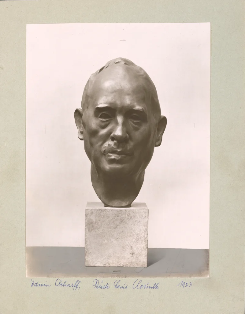 Kopfskulptur auf einem quadratischen Sockel vor hellem Hintergrund