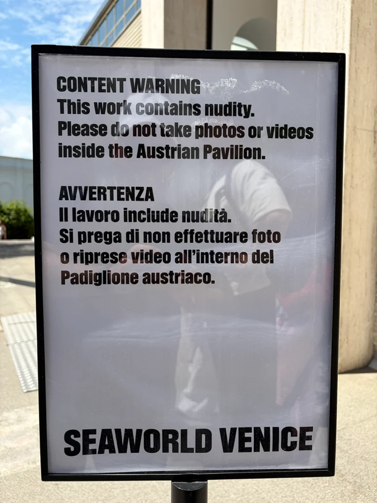 Schild mit Warnhinweis in Englisch und Italienisch vor Nacktdarstellung und Foto- sowie Videoverbot im Austrian Pavilion bei SeaWorld Venice